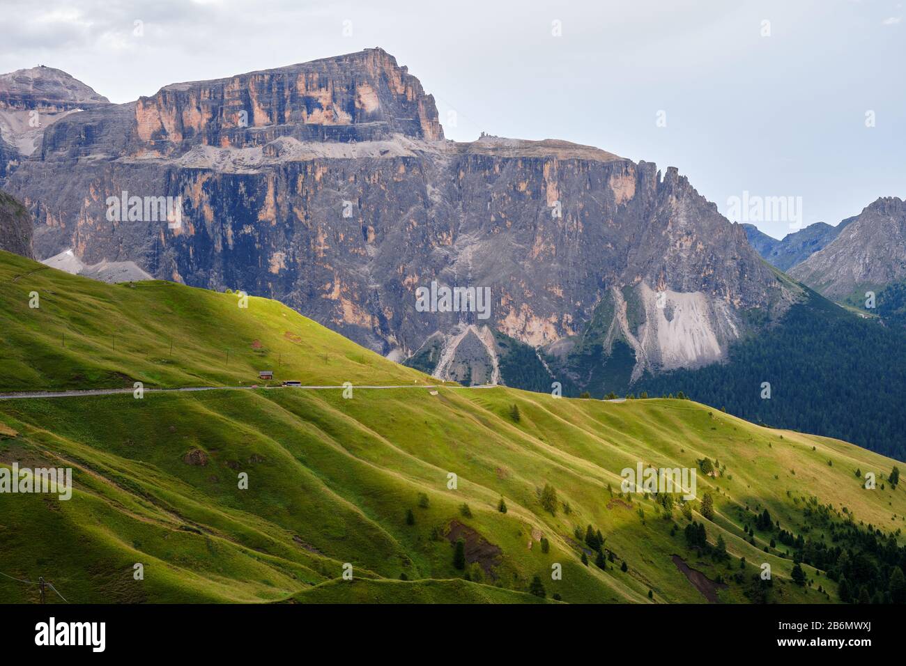 Sella Berggruppe in den Dolmen, Italien, bei Sonnenuntergang, mit Lichtstrahlen über grüne Grasschichten. Stockfoto