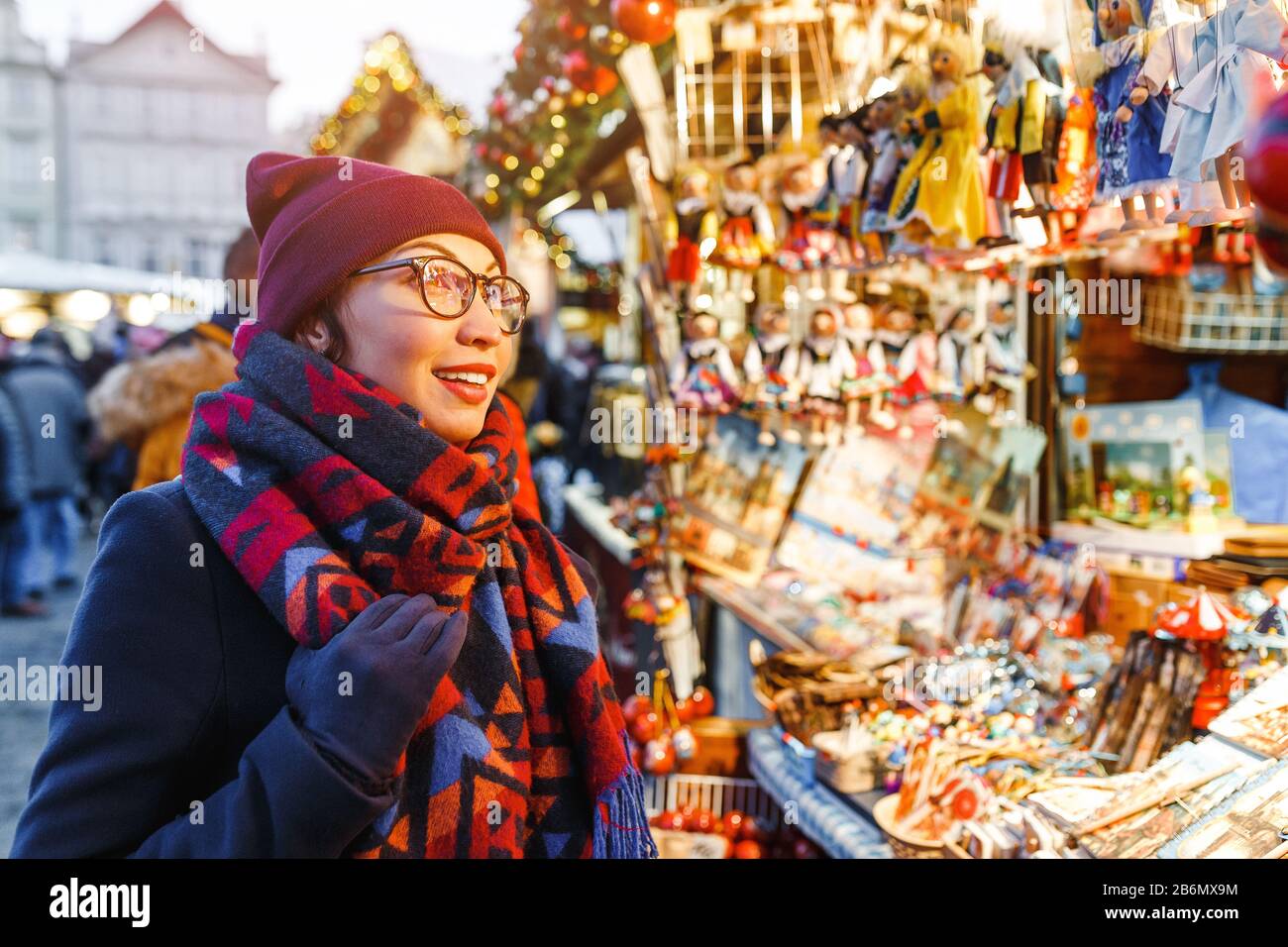 Die stilvolle Frau kauft auf dem Prager Weihnachtsmarkt Geschenke und Souvenirs Stockfoto