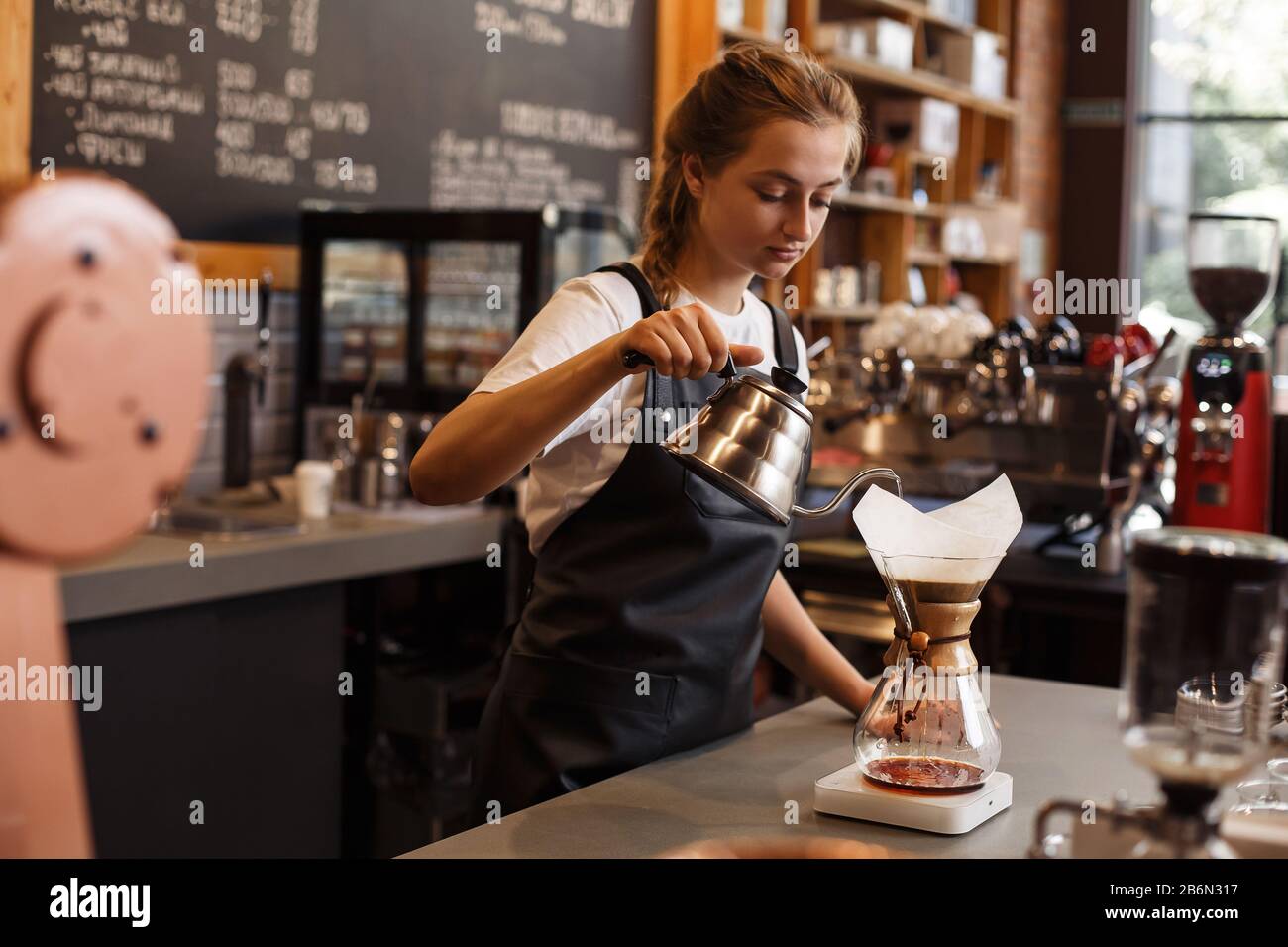 Professioneller Barista, der Kaffee mit chemex über Kaffeemaschine und  Wasserkocher zubereitet. Junge Frau, die Kaffee zubereitet. Alternative  Möglichkeiten zum Brühen von Brühkochs Stockfotografie - Alamy