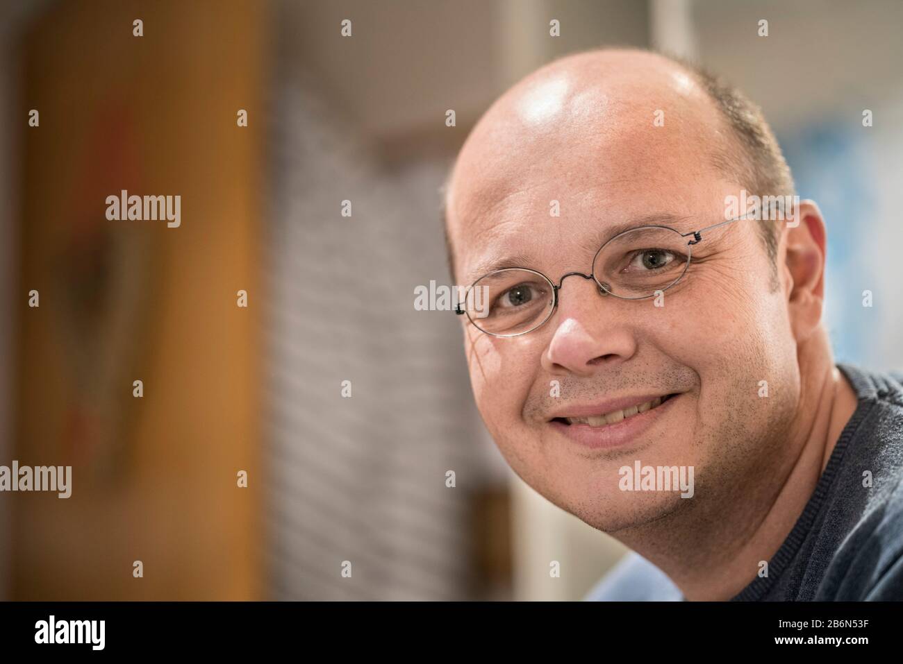 Nahaufnahme im Headshot-Porträt eines lächelnden 50-jährigen Mannes im Innenbereich. Stockfoto