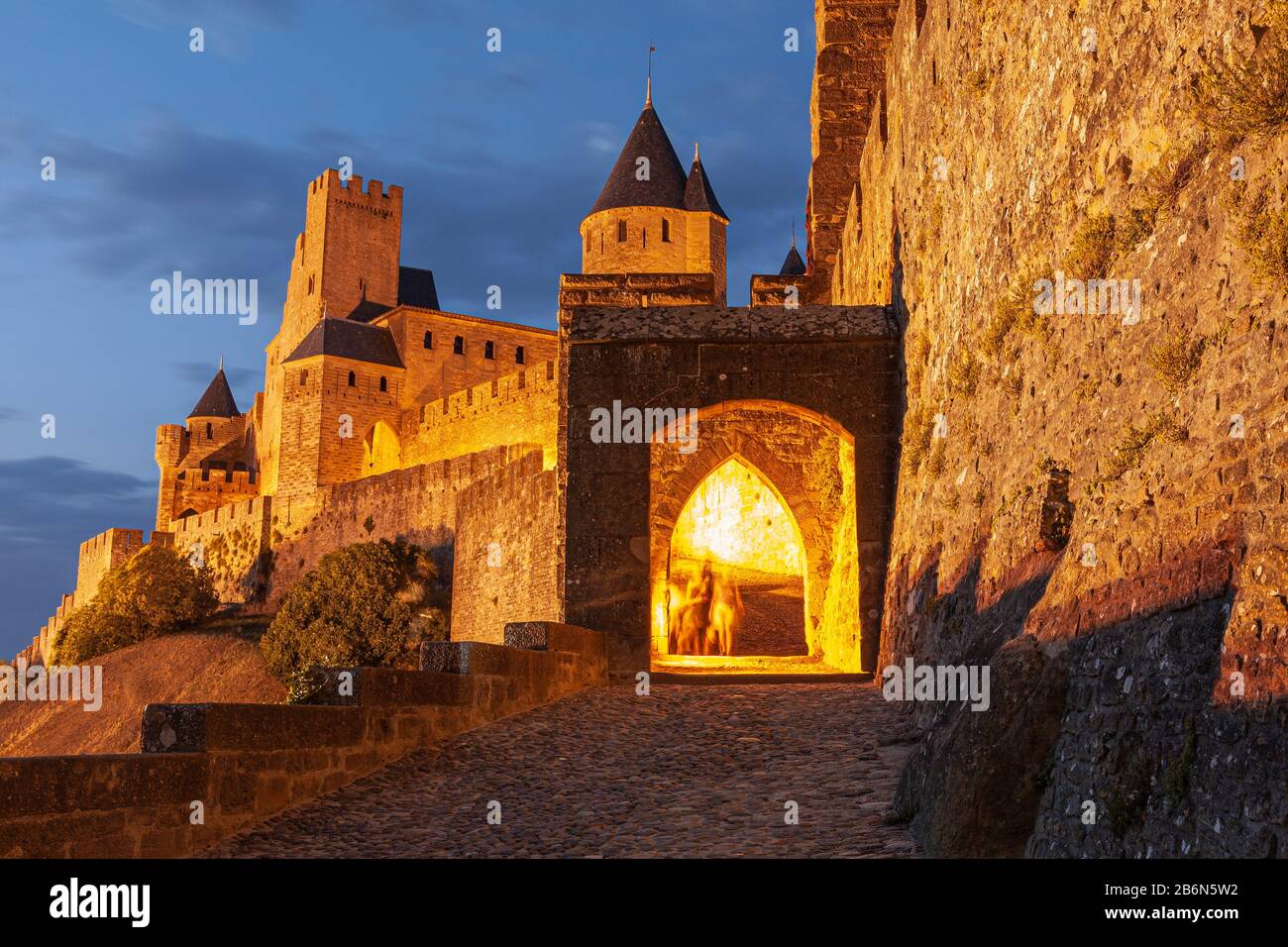 Aude Gate von Carcassonne beleuchtet in der Abenddämmerung, Languedoc-Roussillon, Frankreich Stockfoto