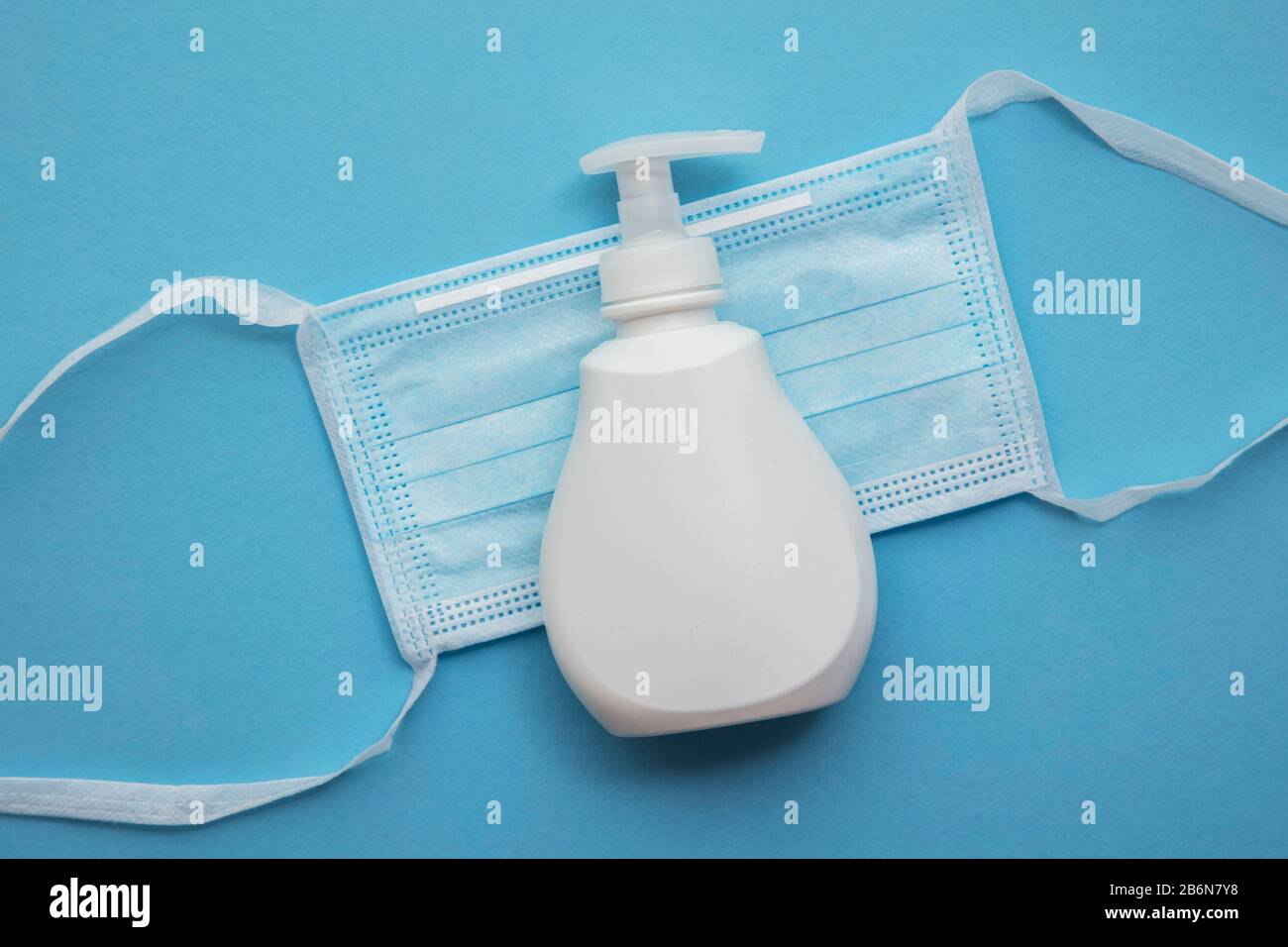 Medizinische Schutzmaske und antibakterielle Handseife auf blauem Hintergrund Stockfoto