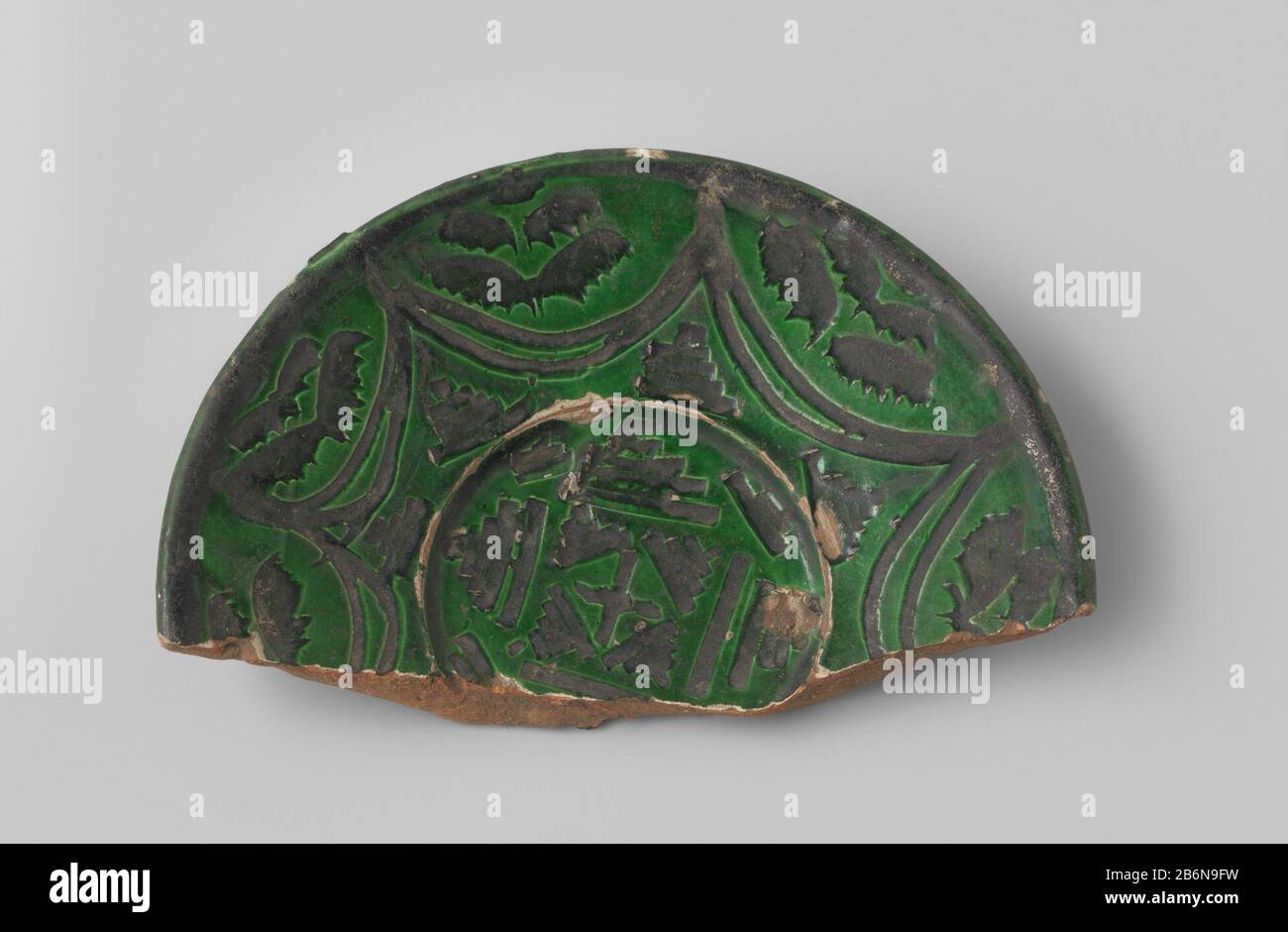 Fragment van een schotel met roodbakkende scherf, voorzien van groen glazuur, met ingekraste geometrisiche patronen in zwart glazuur Fragment van een schotel met roodbakkende scherf, voorzien van groen glazuur, met ingekraste geometrisen patronen in zwart 2-4 glazuf: BK-Typ: 50jämantur: Italië Objekt: Typ: Typ: 1200 - 1899 Material: Aardewerk Abmessungen: H 3,0 cm. × b 19,0 cm. × d 12,4 cm. Stockfoto