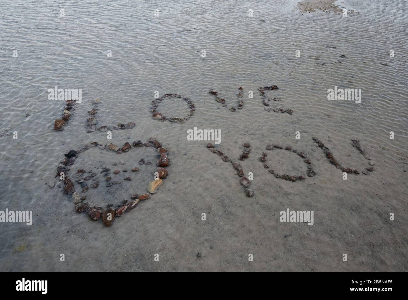 Landschaftsfoto mit den Worten "I Love You", mit einem Herzen in Kieselsteinen an einem Strand in Ägypten Stockfoto