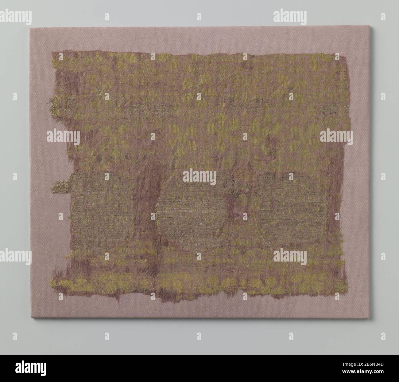 Fragment zijdeweefsel Fragment van paars-gele zijde met zich herhalend patroon van naar elkaar toegewende pauwen en afgewende griffioenen. Das Bladwerk "Hieromheen gestileerd bloem- en". Gemonteerd op karton, en bekt met gaas. Hersteller : Zopfmuster Herstellung: Italië dating: CA. 1.300 - ca. 1399 Material: Ketting en inslag: Zijde lamel Techniek: Brochreen Abmessungen: H 26 cm. × b 31 cm. Stockfoto