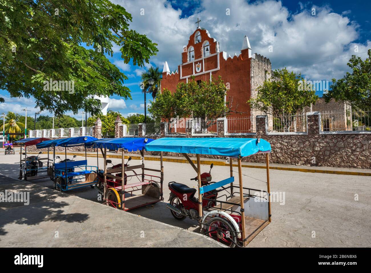 Dreiradtaxis vor Iglesia de Santa Ines im Dorf Dzitas, Bundesstaat Yucatan, Mexiko Stockfoto