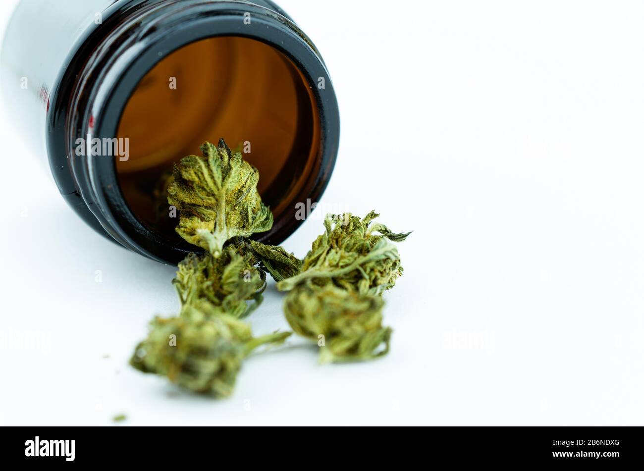 Medizinisches Fläschchen aus schwarzem Glas mit Cannabisknospen im Inneren. Medizinisches Cannabiskonzept Stockfoto