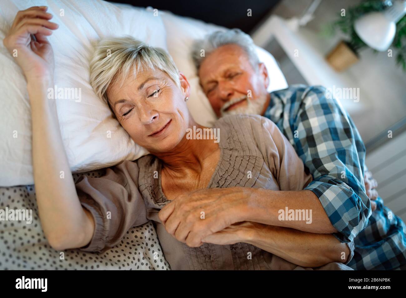 Glücklich lächelnde senior Paar zusammen zu Hause umarmen Stockfoto