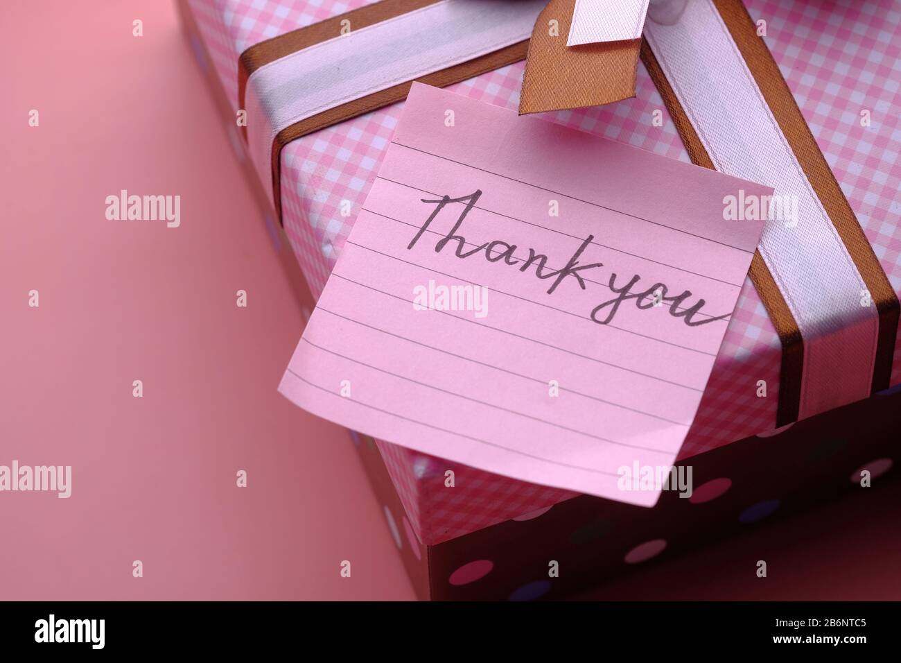Dankesnachricht im Geschenkkarton auf pinkfarbenem Hintergrund Stockfoto