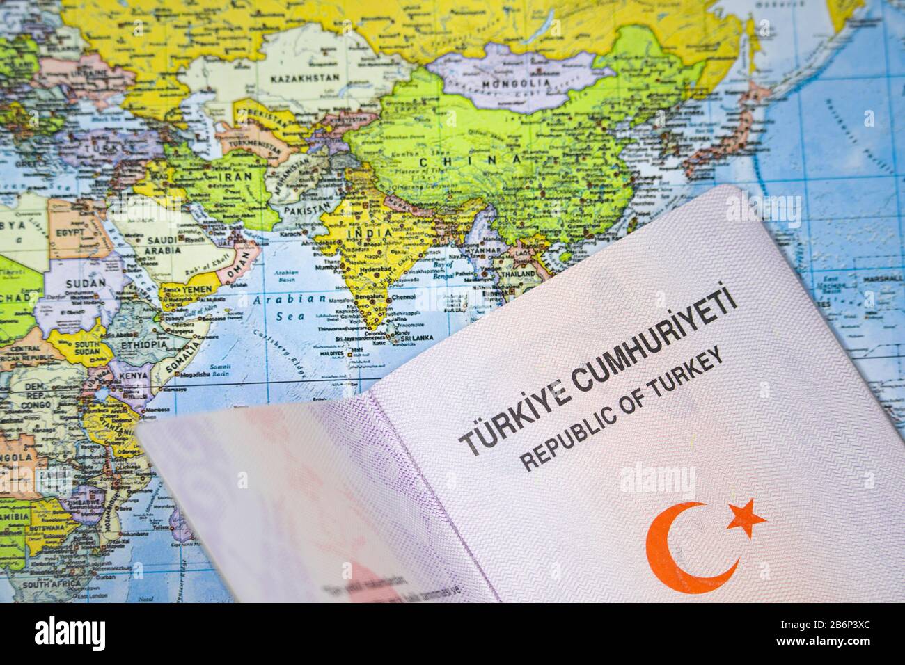 Öffnen Sie den türkischen Pass auf einer Weltkarte. Stockfoto