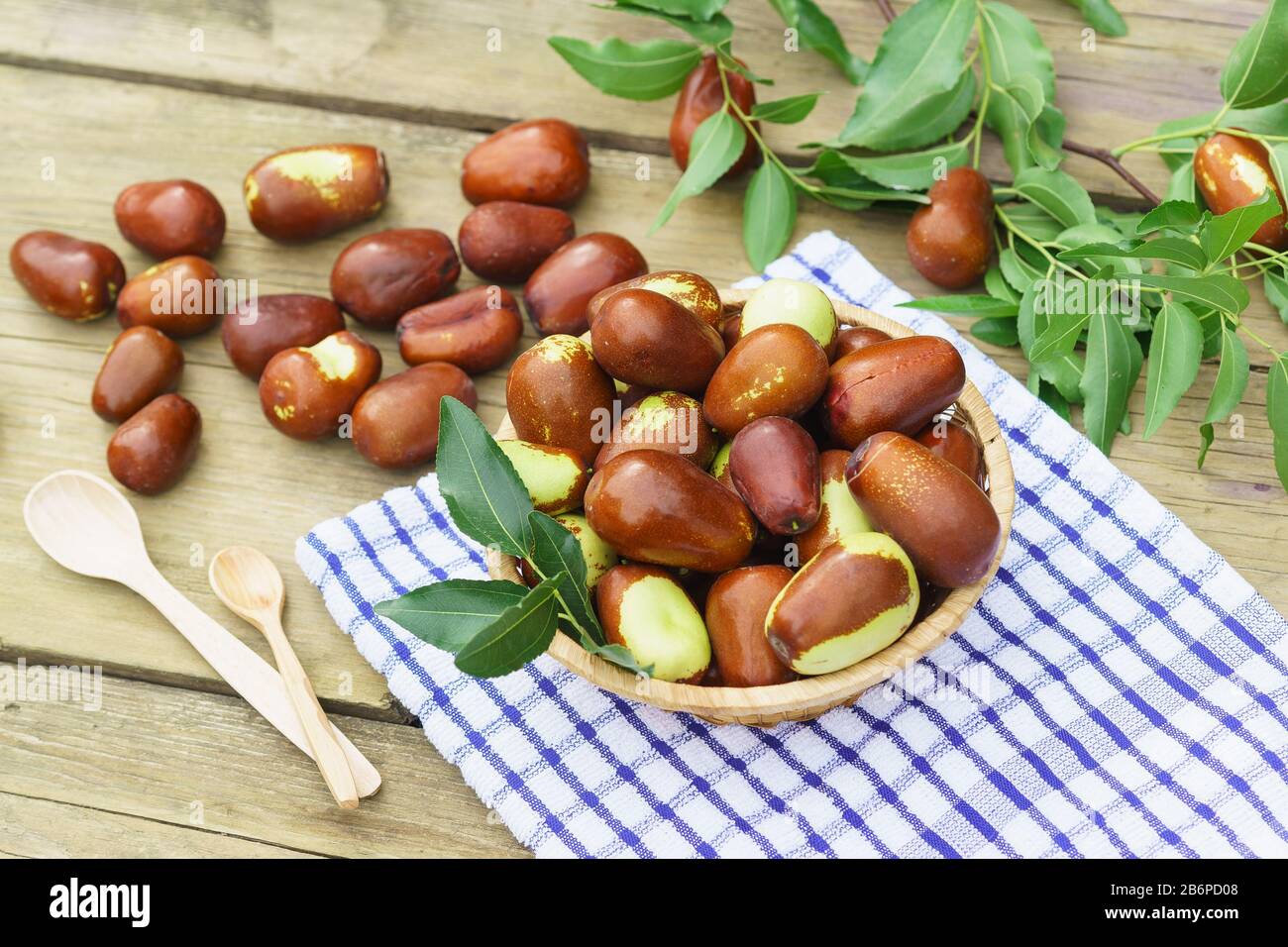 Korbkorb mit Früchten Ziziphus Real, Capiente, Jujube, chinesisches Datum, Capiinit, Jojoba, China-Datum (lat.Ziziphus jujujuba) und Holzlöffel auf dem Stockfoto