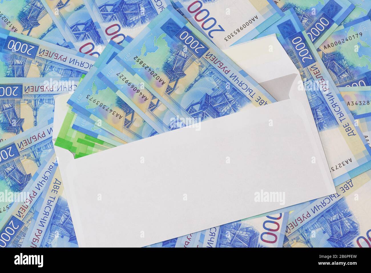 Weißer Umschlag mit Geld auf dem Hintergrund der neuen russischen zweitausendsten Rechnungen. Geld als Geschenk Stockfoto