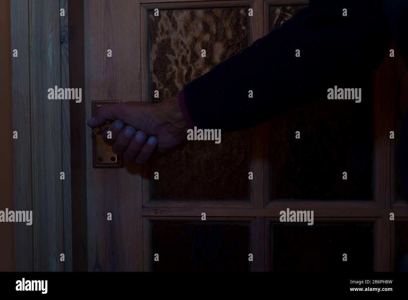 Leicht verschmutzte Innentür zum Öffnen der Hand unter schwarzem Licht, ultraviolett, was zeigt, wie einfach es ist, die Oberfläche zu kontaminieren und die Krankheit zu verbreiten Stockfoto