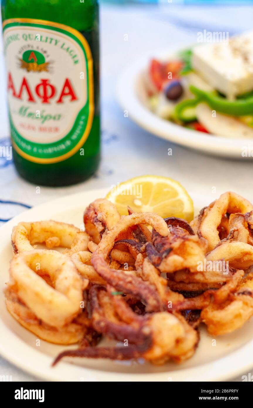 Calamari, griechische Salate und lokales Bier zum Mittagessen Symi Town Symi Greek Islands Griechenland Stockfoto