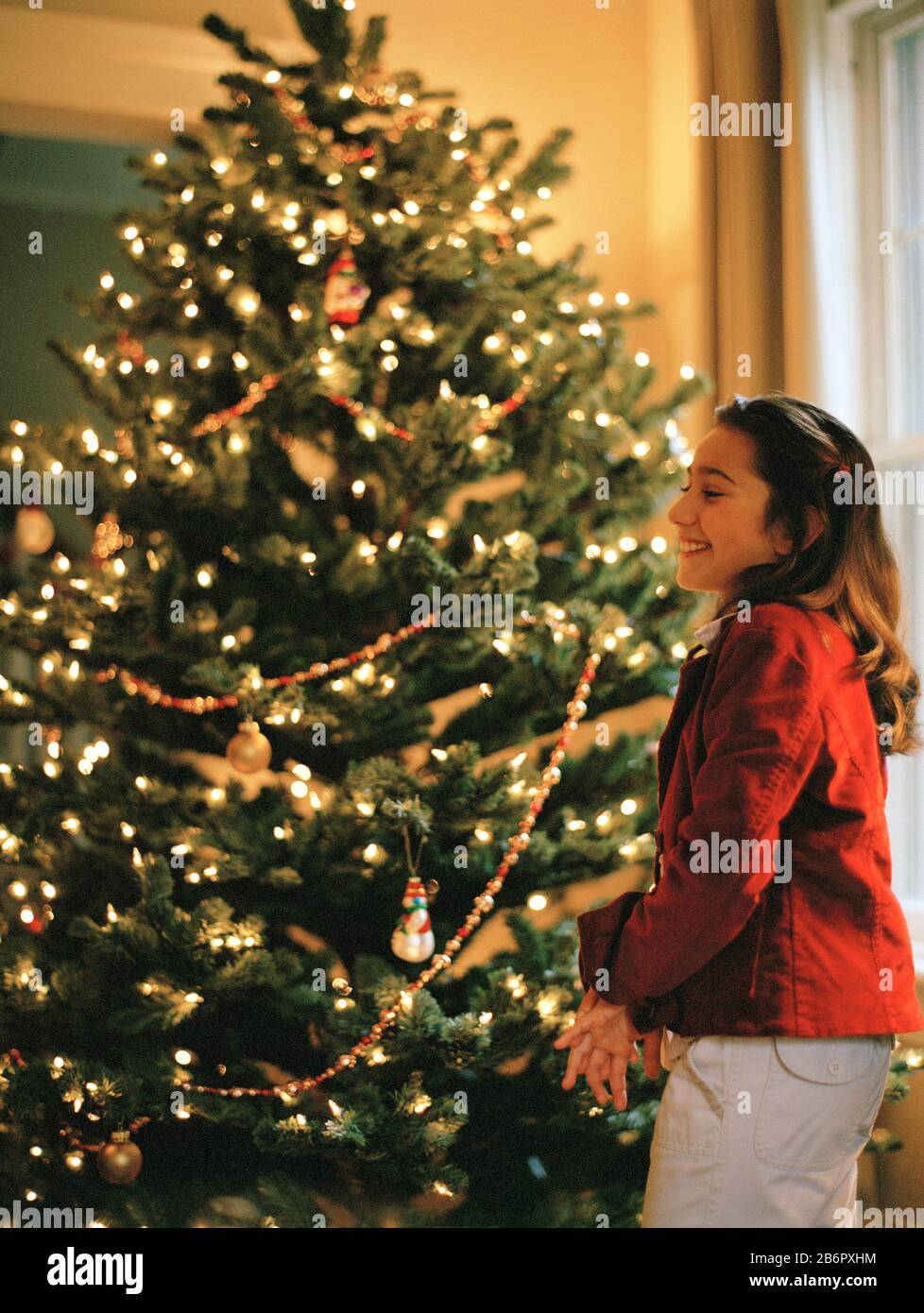 Mädchen stehen vor Weihnachtsbaum Stockfoto