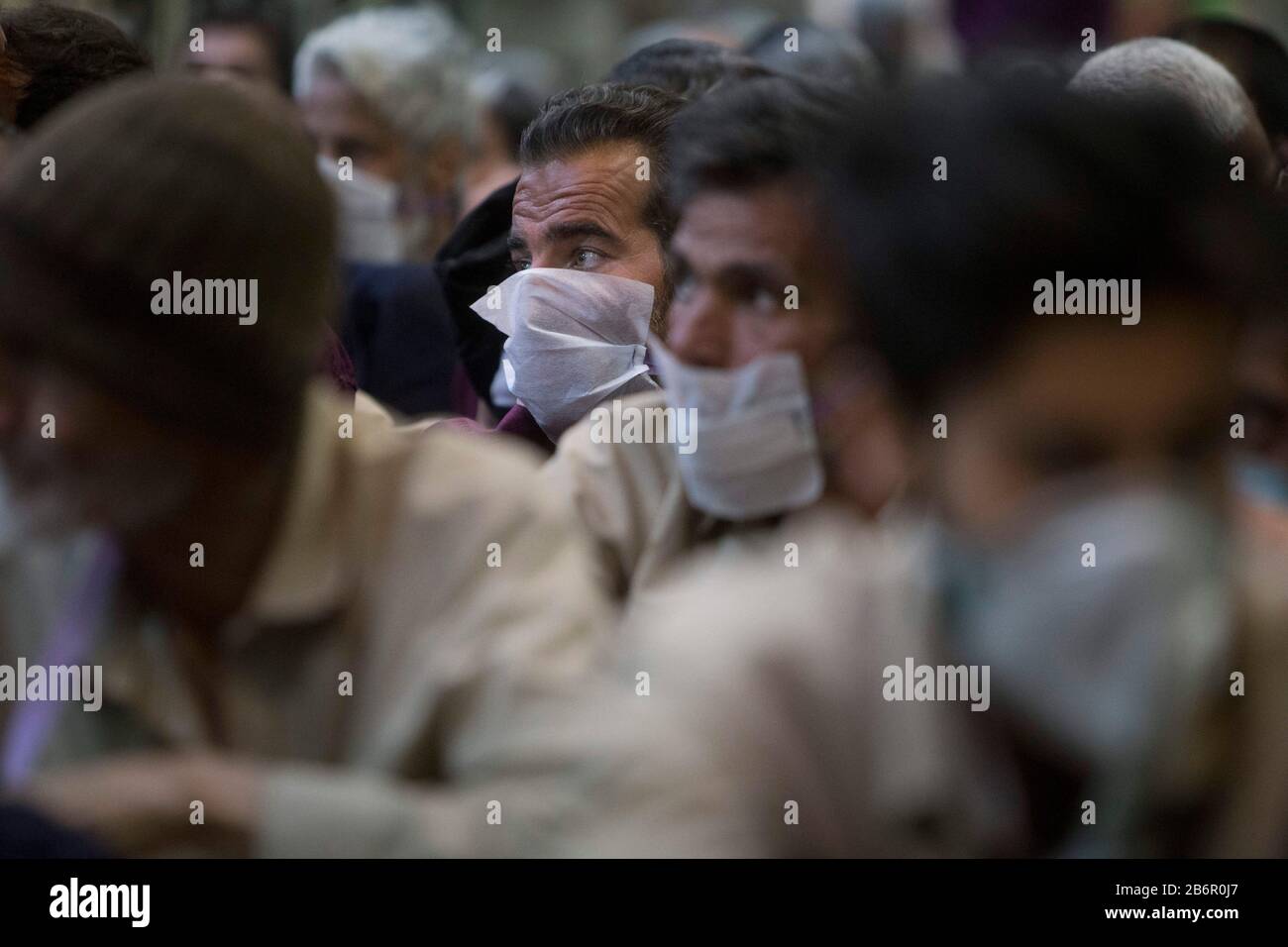 Teheran, Iran. März 2020. Obdachlose Männer, die Gesichtsschutzmasken und saubere Kleidung tragen, werden nach der Desinfektion und dem Duschen im Süden Teherans nach einem neuen Coronavirus (Covid-19) im Iran in Khavaran Obdachlose Obdachlosen gesehen. Die Khavaran-Halle soll 600 Personen beherbergen. Diese Kapazität wird in der Winternacht auf 1.100 ausgedehnt. In der Anlage sind auch Saisonarbeiter untergebracht, die duschen, eine warme Mahlzeit pro Tag essen und dort schlafen. Kredit: Zuma Press, Inc./Alamy Live News Stockfoto