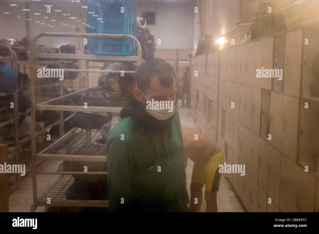 Teheran, Iran. März 2020. Obdachlose Männer entfernen ihre Kleidung, nachdem sie nach einem neuen Ausbruch des Coronavirus (Covid-19) im Iran in Khavaran Obdachlose Shelter im Süden Teherans desinfiziert haben. Die Khavaran-Halle soll 600 Personen beherbergen. Diese Kapazität wird in der Winternacht auf 1.100 ausgedehnt. In der Anlage sind auch Saisonarbeiter untergebracht, die duschen, eine warme Mahlzeit pro Tag essen und dort schlafen. Kredit: Zuma Press, Inc./Alamy Live News Stockfoto