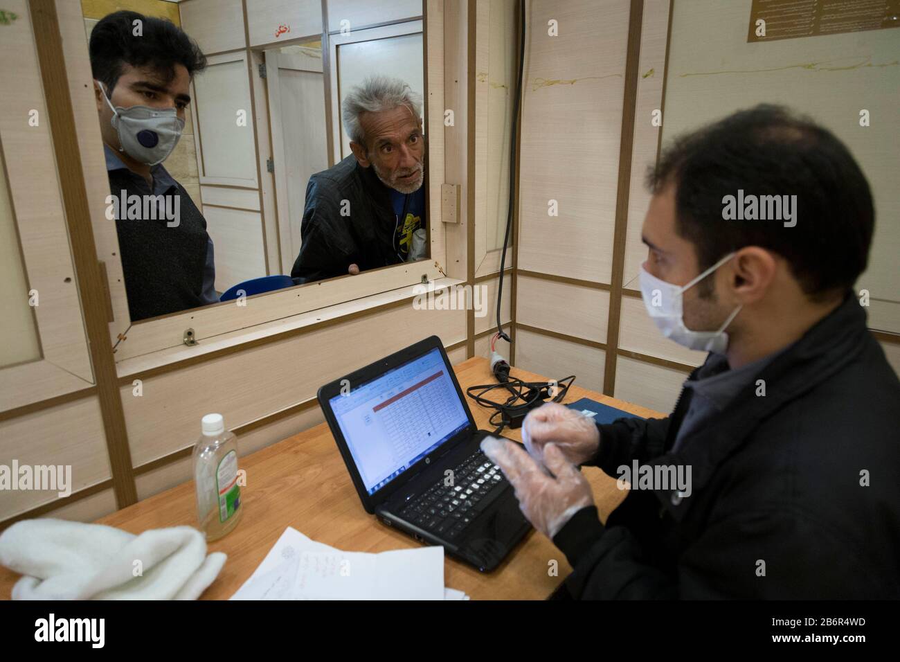 Teheran, Iran. März 2020. Ein Mitarbeiter registriert einen Obdachlosen, um Khavaran Obdachlosen in SüdTeheran nach einem neuen Coronavirus (Covid-19) Ausbruch im Iran zu verstricken. Die Khavaran-Halle soll 600 Personen beherbergen. Diese Kapazität wird in der Winternacht auf 1.100 ausgedehnt. In der Anlage sind auch Saisonarbeiter untergebracht, die duschen, eine warme Mahlzeit pro Tag essen und dort schlafen. Kredit: Zuma Press, Inc./Alamy Live News Stockfoto