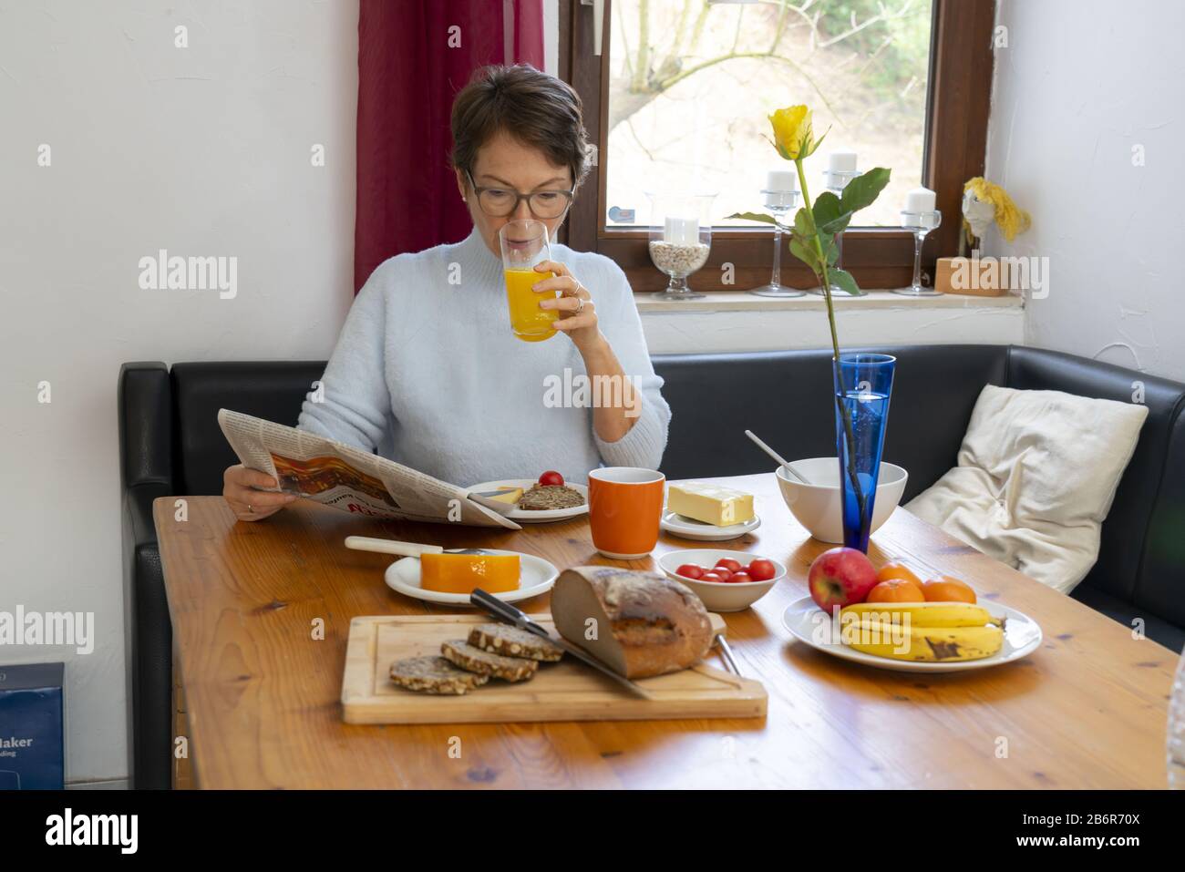 Frau beim Frühstück, zu Hause, gesundes Frühstück, mit Tee, Obst, Vollkornbrot, Müsli, Stockfoto