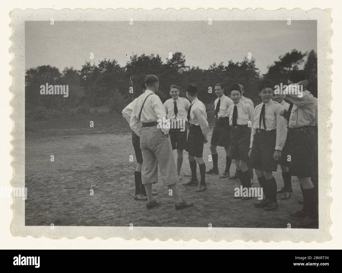 Groep Jeugdstürmer, Pratend Jeugdstorm (serietitel) EINE Gruppe von Jungen und Erwachsenen in der Uniform des (nationalen) Jeugdstorms, die sich während eines Jugendlagers außerhalb der Gespräche untereinander aufhielten. Links C. Geelkerken, Gründer des Jugendsturms plus vier auf den hinteren Gezien. Hersteller : Fotograf: NSBfotograaf: Anonymer Ort Herstellung: Bilt Gericht Datum: Okt 1934 - 1935 Physikalische Merkmale: Gelatine silberfarbenes Druckmaterial: Papiertechnik: Fotografie Abmessungen: H 5,5 cm. B × 8 cm. ToelichtingDe Foto ist Teil einer Serie von etwa 35 amateurfoto's. Betrifft: Zweite Welt, Wenn: 1933 - 1944 Stockfoto