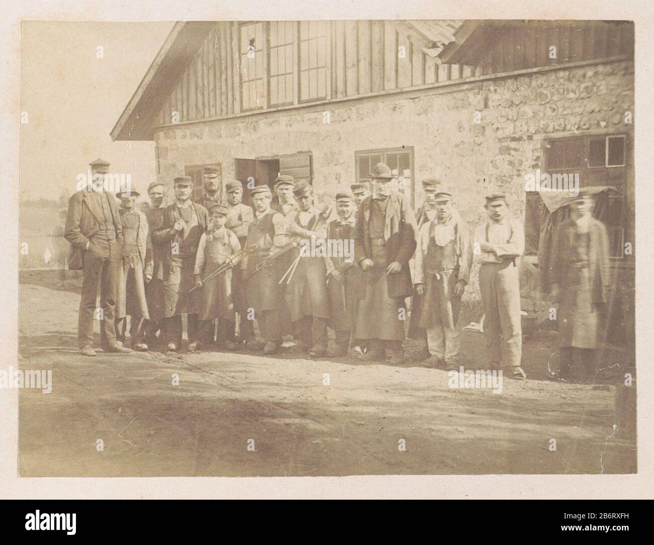 Groepsportret van werksemers voor een werkplaats Arbetspersonaten vir Wikmanshyttan (titel op object) Een groep mannen posseert voor een werkplaats, Stockfoto