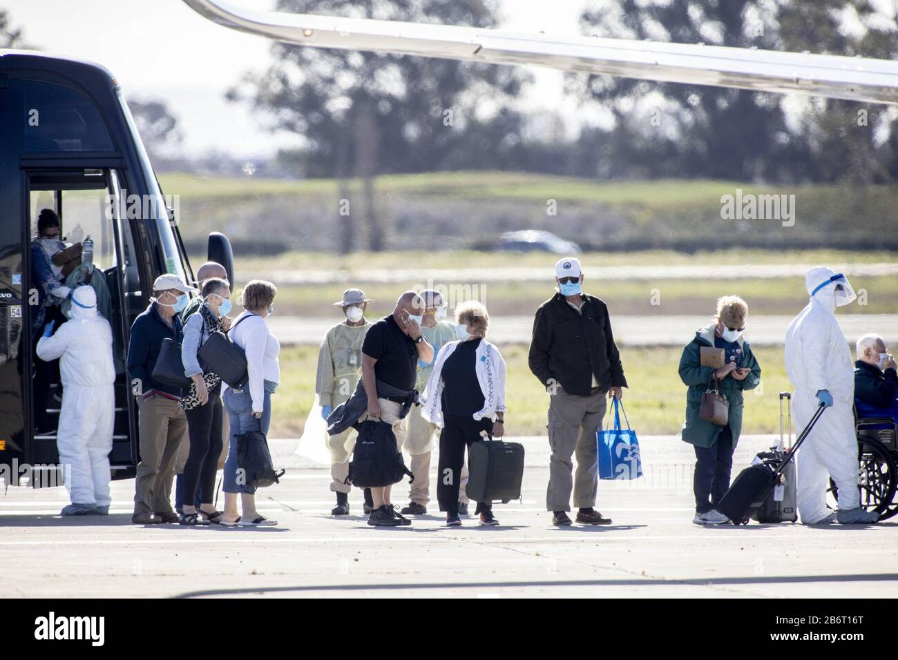 Oakland, Vereinigte Staaten. März 2020. Medizinisches Personal hilft Passagieren des Kreuzfahrtschiffs Grand Princess am Mittwoch, den 11. März 2020, an Bord eines gecharterten Flugzeugs am Oakland International Airport in Oakland, Kalifornien. Foto von Peter DaSilva/UPI Credit: UPI/Alamy Live News Stockfoto