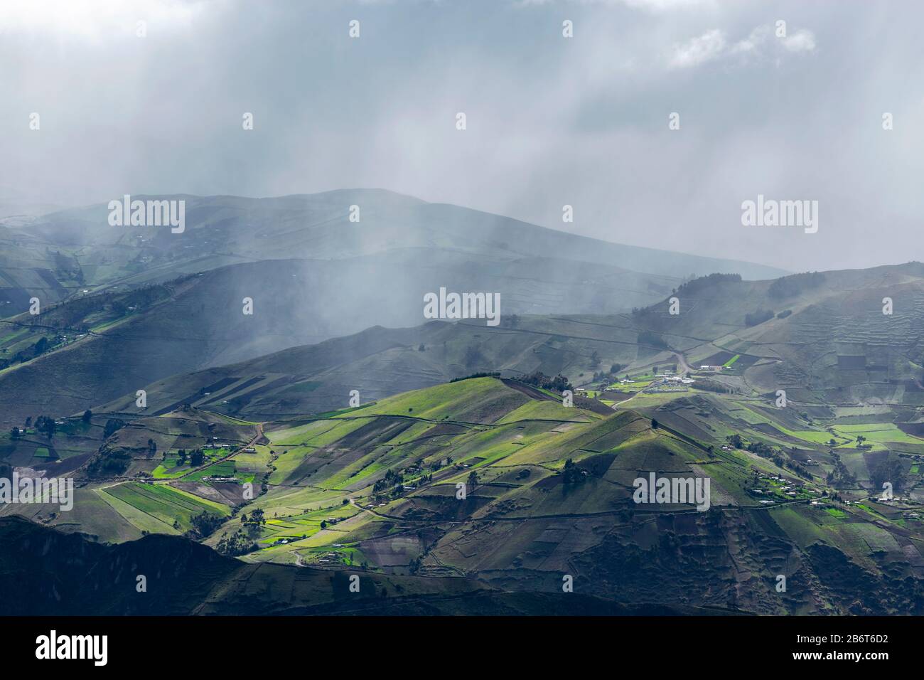 Dramatische Landschaft der Anden mit grünen Agrarfeldern und Regenfällen in der Nähe von Quito, Ecuador. Stockfoto