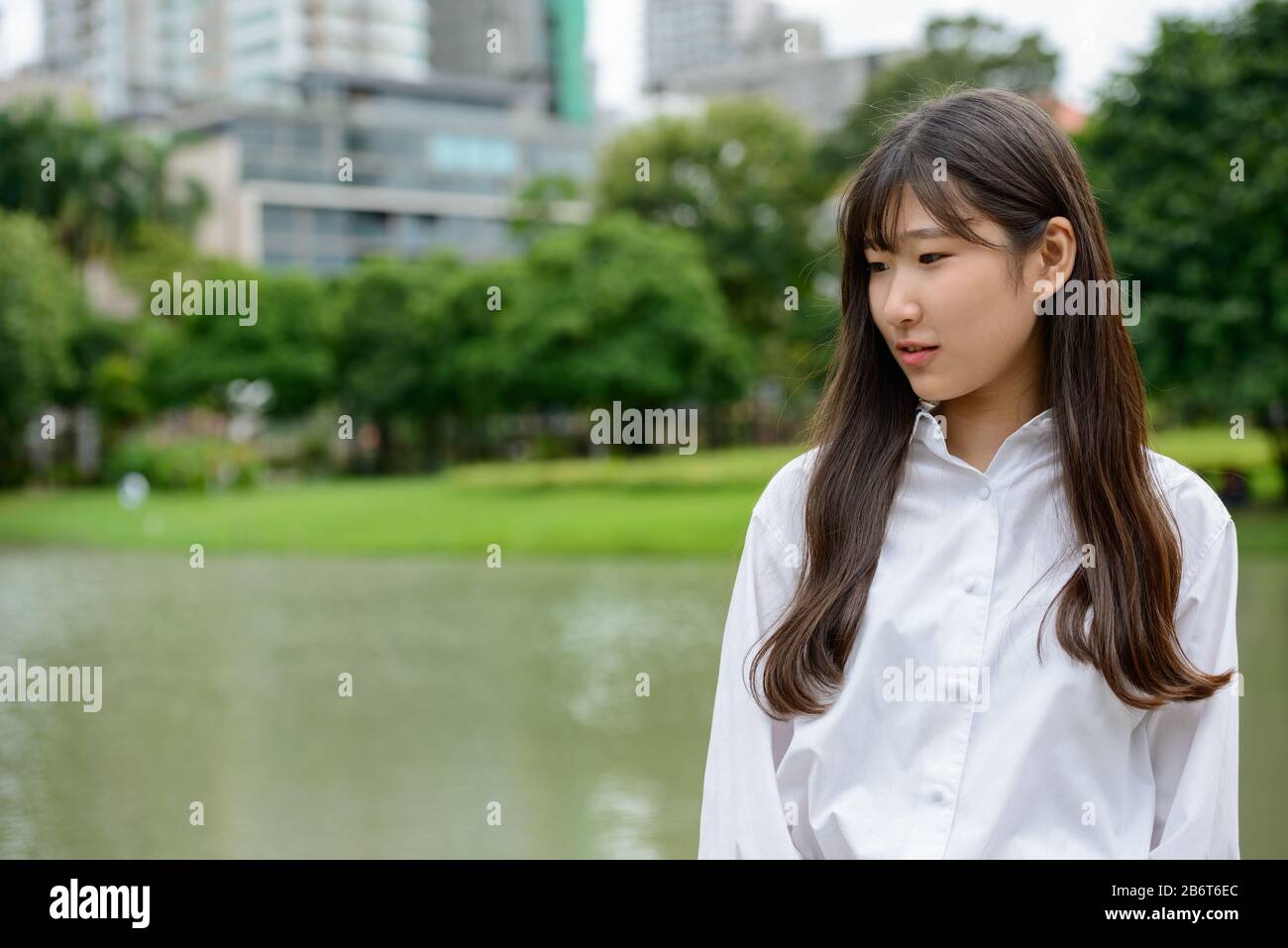 Junge schöne asiatische Teenager-Mädchen im Park denken Stockfoto