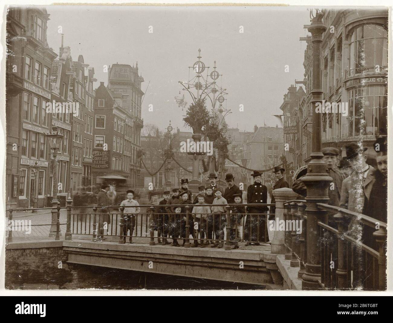 Het Koningsplein vanaf het Singel, gezien naar de Leidsestraat, versierd ter gelegenheid van het huwelijk van koningin Wilhelmina en prins Hendrik, Amsterdam, Nederland The Royale from the Singel, in Anbetracht der Leidsestraat, die anlässlich der Hochzeit von Königin Wilhelmina und Prinz Hendrik, Amsterdam, Niederlande, dekoriert wurde. An der rechten Ecke Herengracht und Kindermagazin Neuengland. Im Vordergrund, an der Brücke mehrere Mensen. Hersteller : Fotograf: Anonymer Ort Herstellung: Amsterdam Datum: 1901 Physikalische Merkmale: Dolchcollodiumzilverdruk auf Papiermaterial: Papiertechn Stockfoto