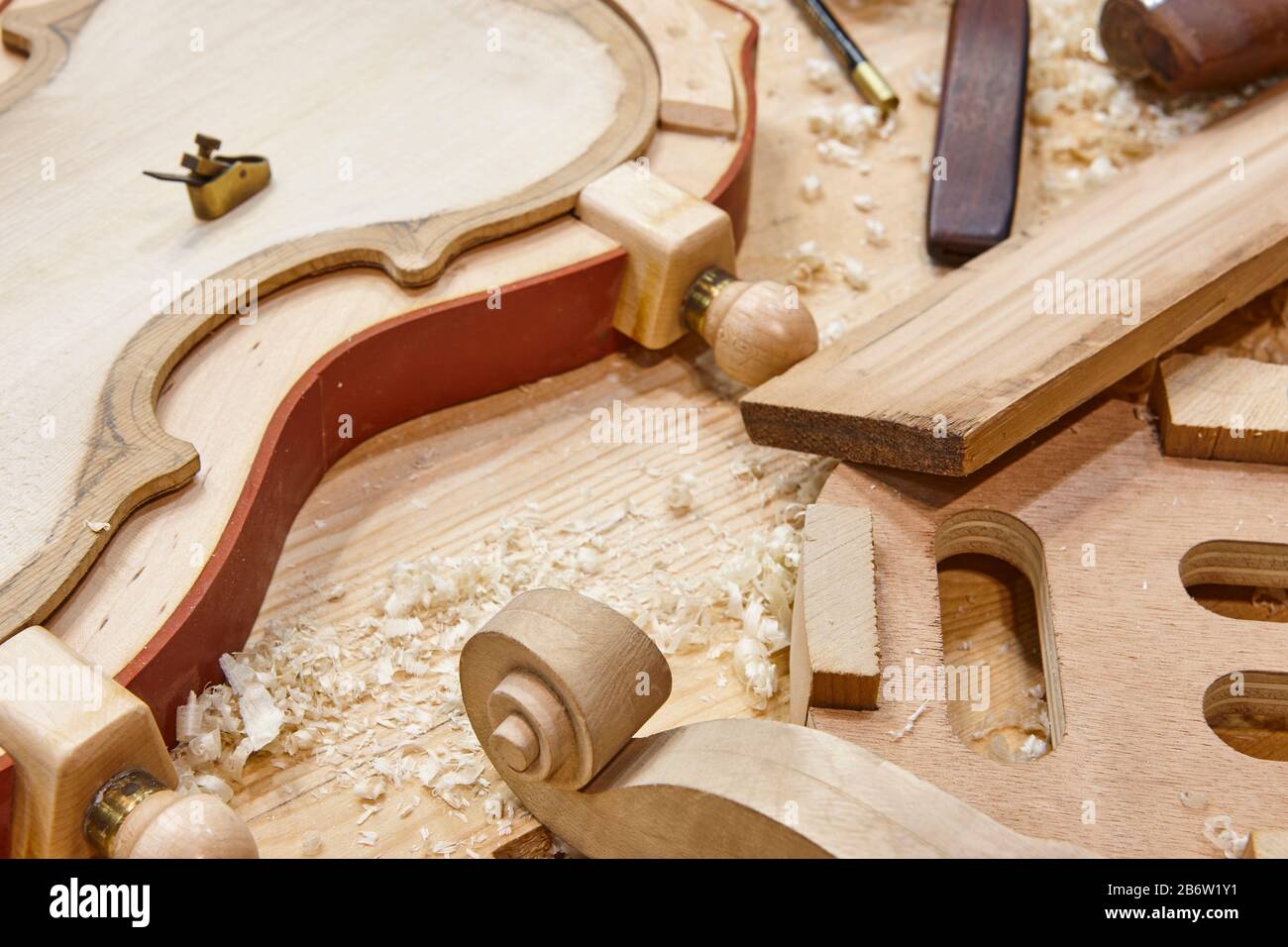 Luthier-Werkstatt mit Geigenholzteilen und -Werkzeugen. Traditionelle Handwerkskunst. Stockfoto