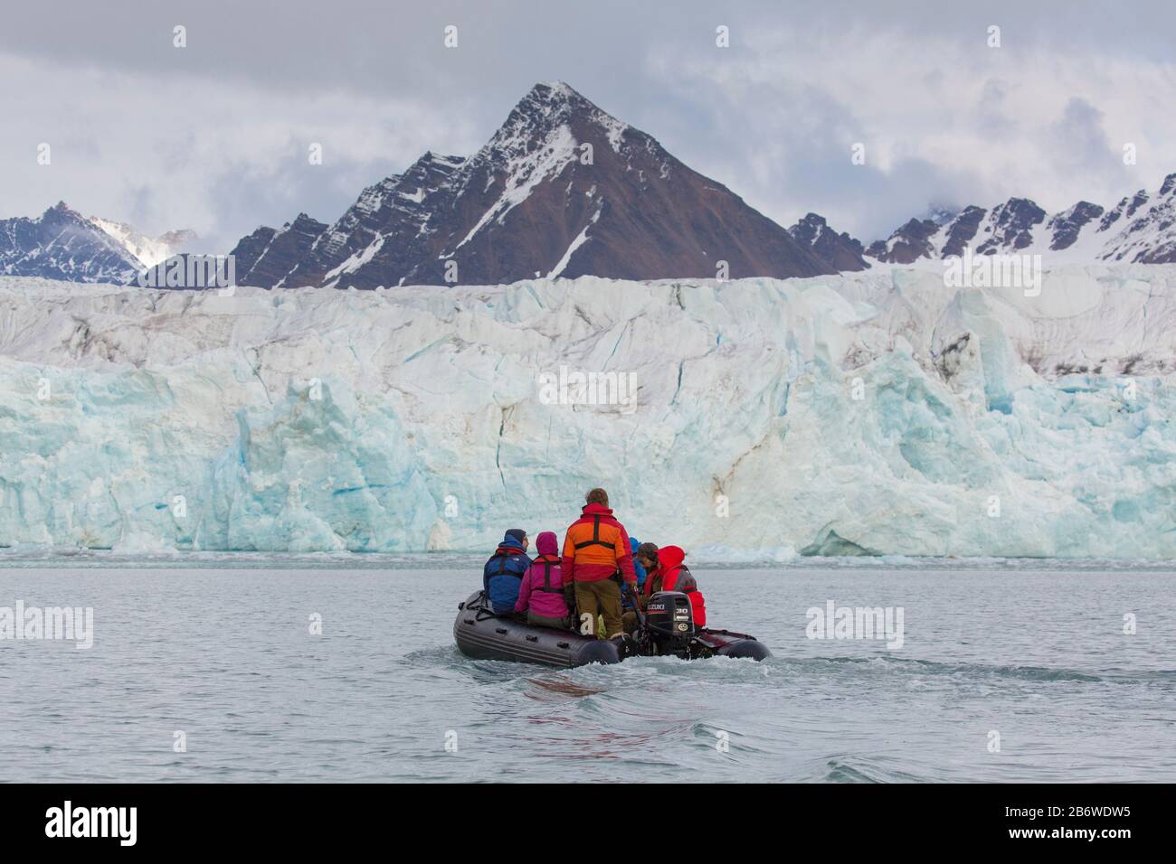 Touristen in einem aufblasbaren Boot vor dem Fjortende-Julibreen-Gletscher (14. Juli Glacier) am Krossfjorden, Spitzbergen, Norwegen Stockfoto