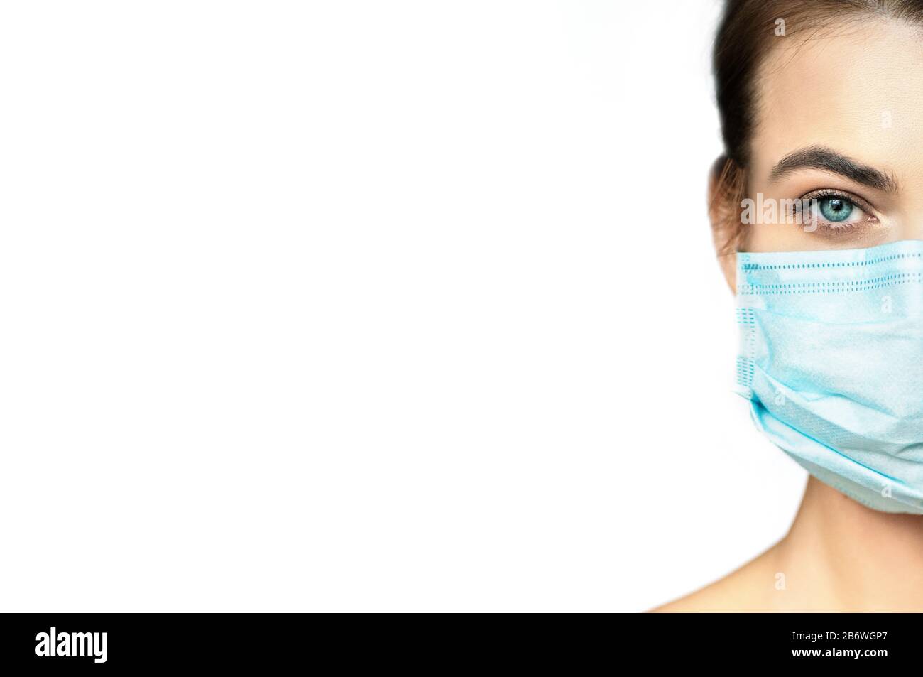 Teilansicht der jungen Frau in medizinischer Schutzmaske auf weißem Hintergrund mit Kopierraum. Stockfoto