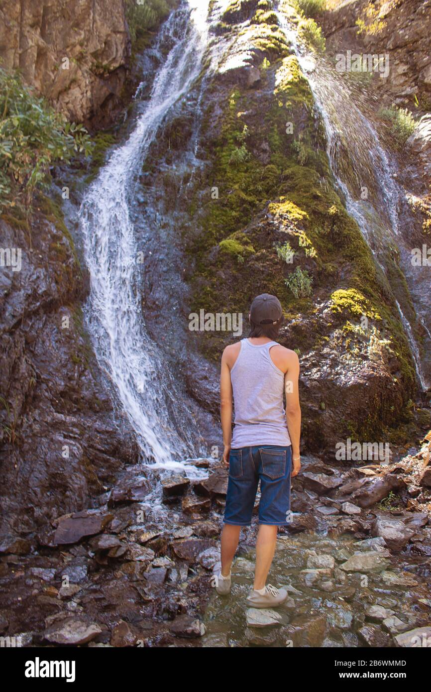 Wanderer mit Blick auf den großen Wasserfall in den Bergen, Region Kasachstan Stockfoto