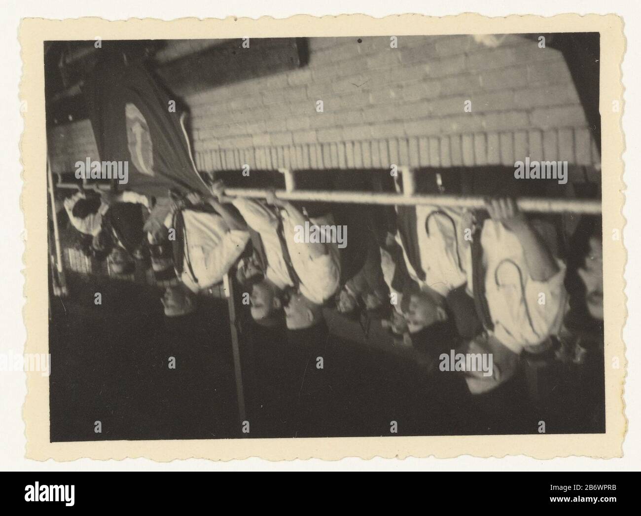 Jeugdstorm in een Stadium Jeugdstorm (serietitel) Gruppenführer Jeugdstorm stand in Uniform hinter einer niedrigen Mauer, vermutlich in einem Stadion. Vierter von links ist der Anführer des Jeugdsturms C. Geelkerken. An der Wand hängt die Fahne des Jugendsturms. Dahinter steckt mehr Mensen. Hersteller : Fotograf: Anonymer Ort Herstellung: Niederlande Datum: 1934 - 1940 Material: Papiertechnik: Fotografie Abmessungen: H 5,5 cm. B × 8 cm. Betrifft: Zweite Welt, Wenn: 1933 - 1944 Stockfoto