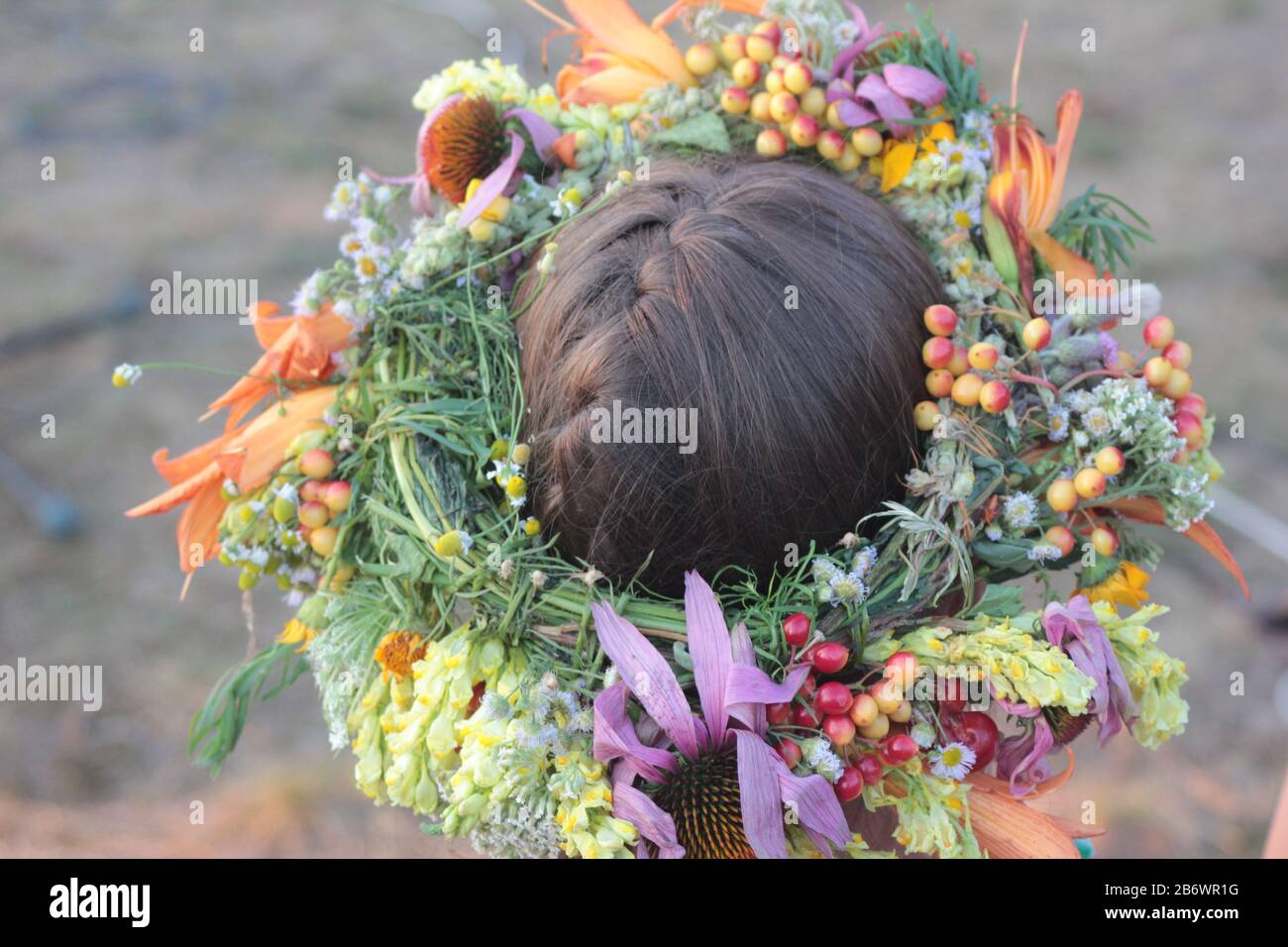 Kopf des Mädchens in einem Kranz aus Wildblumen, junge Frau in einem Blumenkränz, in der Nähe, Rückansicht. Hochsommerfeiern Kupala-Nacht in der Ukraine Stockfoto