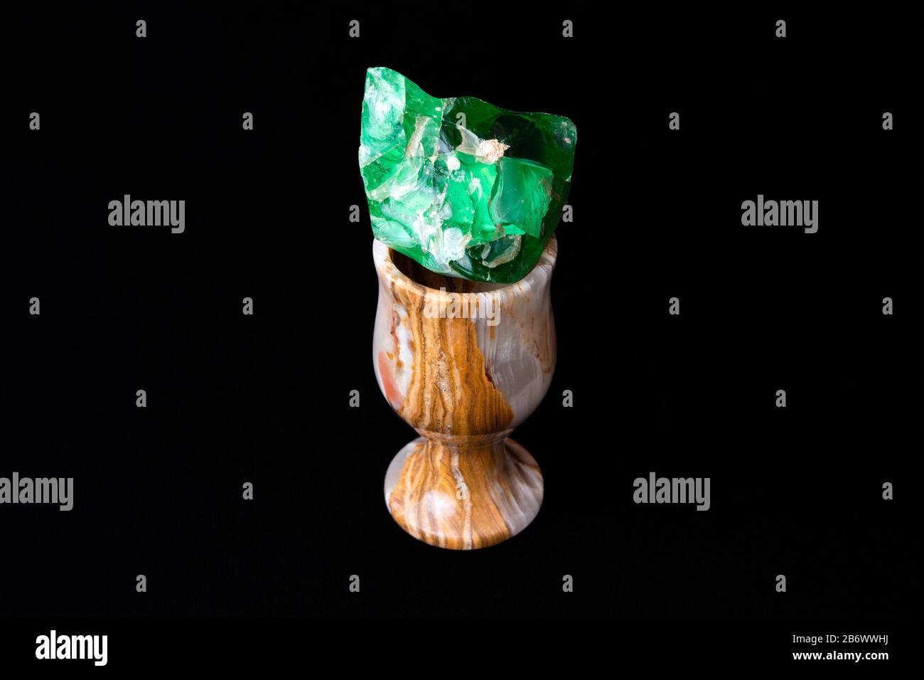 Kleines elegantes Steinglas aus natürlichem Onyx mit grünem Glas im Inneren Stockfoto