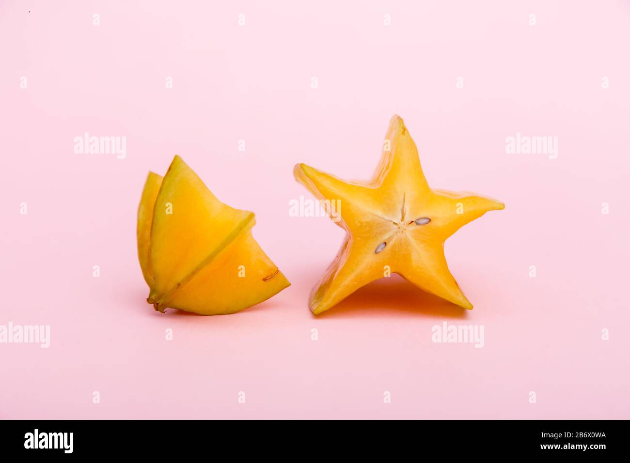 Sternfrucht-Karambola oder starfrucht mit Scheibe auf pinkfarbenem Hintergrund. Gesunde Fruchtnahrung. Stockfoto