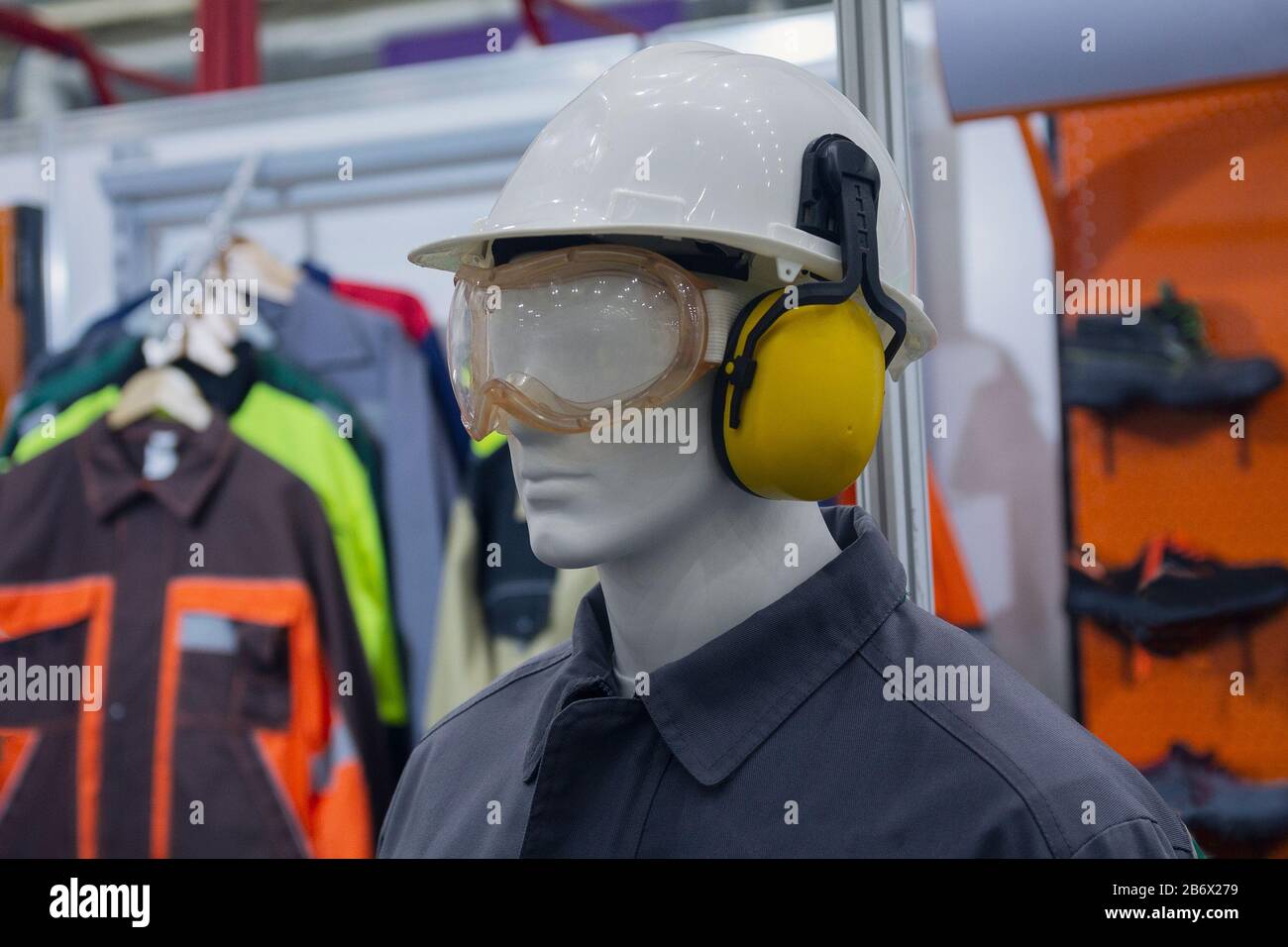 Mannequin mit Kleidung, Handschuhen und speziellen Schutzmitteln im Ausstellungsraum. Branche Stockfoto