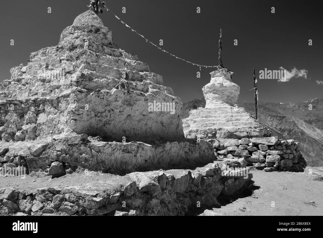 Alte buddhistische Stupas, die mit Schlamm aufgeputzt und im Sommer in Nako, Himachal Pradesh, Indien mit Gebetfahnen im Himalaya unter blauem Himmel weiß wurden. Stockfoto