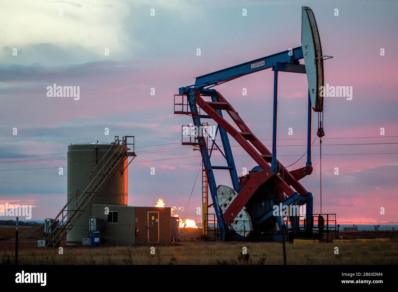 Eine Ölbohrinsel und Lagertanks außerhalb von Williston in North Dakota. Das Gebiet gehört zum Bakken-Ölfeld, wo die Fracking-Technologie es profitabel machte, solange der Ölpreis über 46 USD pro Barrel bleibt. Stockfoto