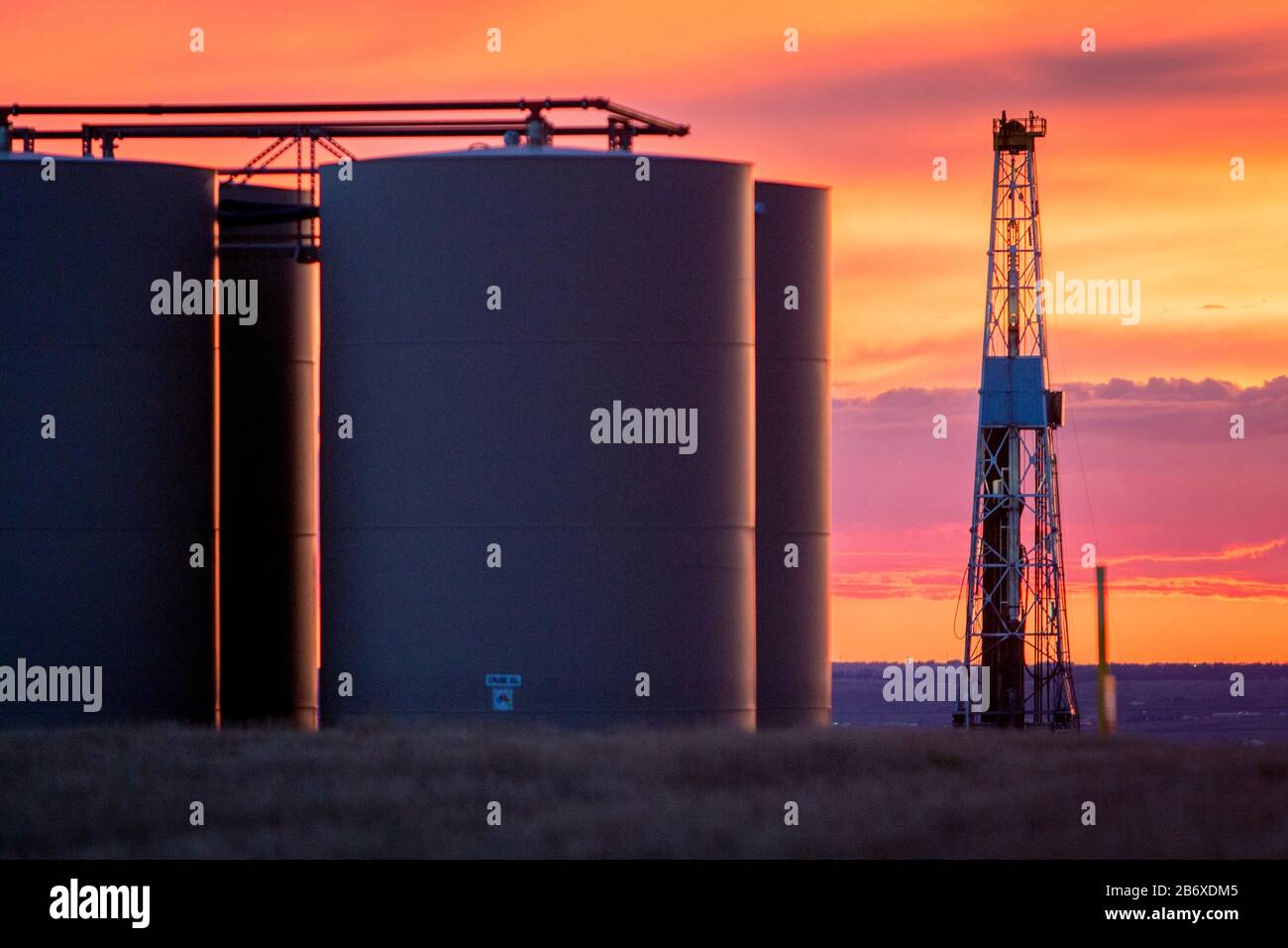 Eine Ölbohrinsel und Lagertanks außerhalb von Williston in North Dakota. Das Gebiet gehört zum Bakken-Ölfeld, wo die Fracking-Technologie es profitabel machte, solange der Ölpreis über 46 USD pro Barrel bleibt. Stockfoto