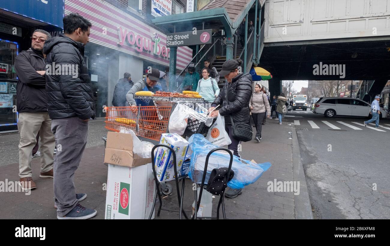 Zwei südamerikanische Frauen verkaufen Mais und Huhn von einem Stand an der 82nd Street in Jackson Heights, Queens, New York City. Stockfoto