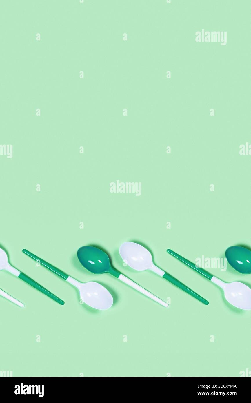 Kunststofflöffel auf mintgrünem Hintergrund. Flaches Layout, Kopierbereich in der Draufsicht. Stockfoto