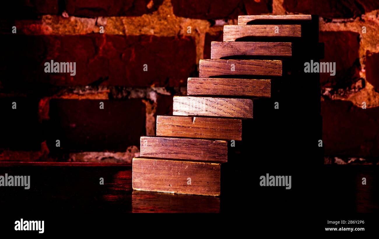 Geschäftsrisiko-Konzept mit Holzplanke vor dem Hintergrund einer roten Ziegelwand. Stockfoto
