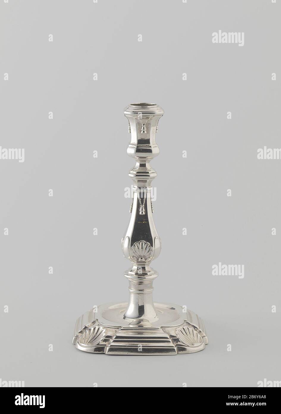 Kandelaar op vierkante voet met inspringende, ronde hoeken versierd met schelpen Kandelaar van zilver. De vierkante, geprofileerde, zich verjongende voet heeft inspringende, ronde hoeken die zijn versierd met een schelp. In de vlakke bovenzijde bevindt zich een ronde verdiping Stockfoto