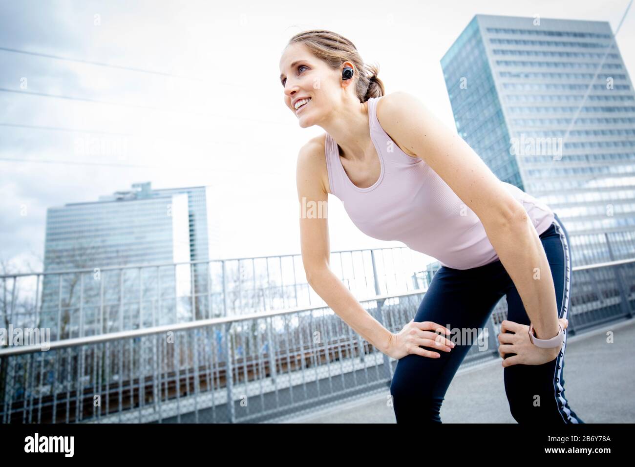 Die Sportlichkeit der Frau hat nach dem Training ihren Atem. Weibliche Läuferin macht sich beim Joggen eine Pause. Frau Athletin erholte sich nach dem Workout Stockfoto