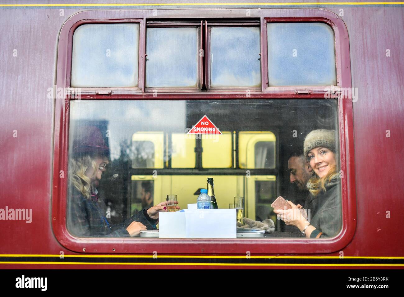 Racegoers blicken von den alten Eisenbahnwaggons Toddington Station, Gloucestershire, aus, wo sie einen Dampfzugdienst zu Cheltenham Rennen, die während des Festivals laufen, fangen. Stockfoto