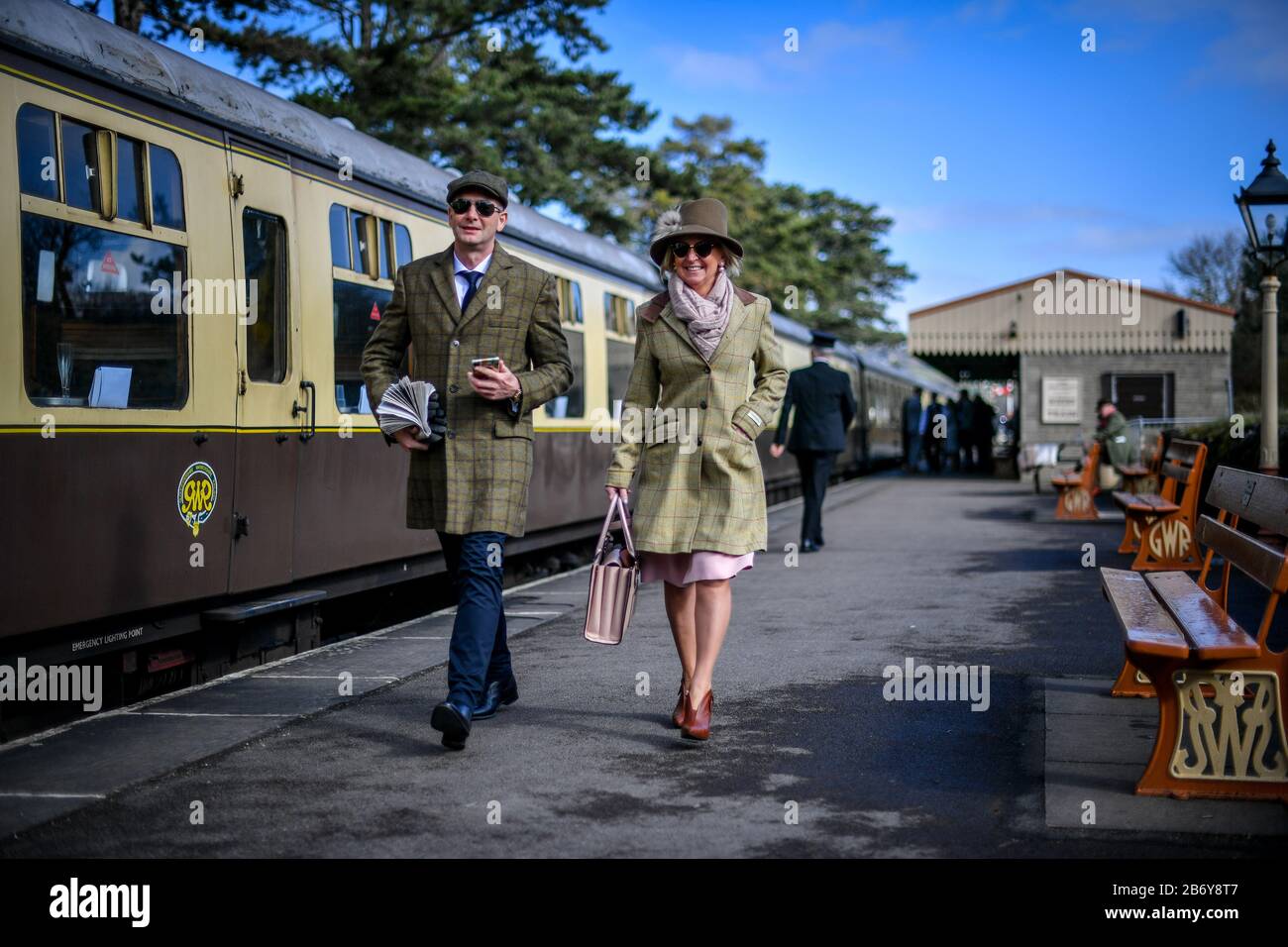 Racegoers machen sich nach einem Höhenzug von einem Oldtimer-Zugwagen auf die Rennbahn Cheltenham, wo die Leute einen Dampfzugdienst zu Cheltenham Rennen von Toddington, der während des Festivals läuft, fangen. Stockfoto