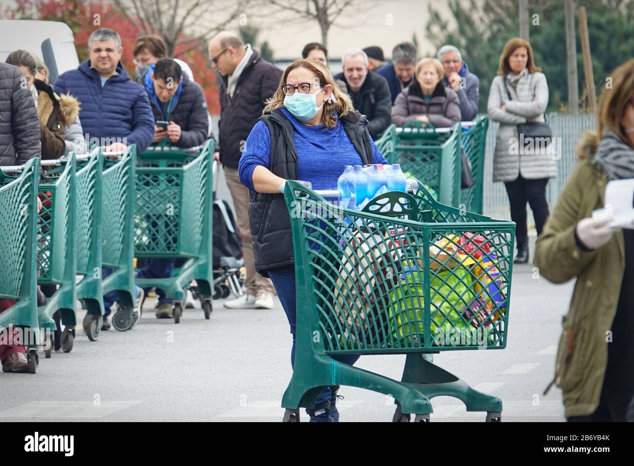 Coronavirus pandemic Effects: Lange Schlange, um den Supermarkt für Lebensmittelgeschäfte zu betreten. Mailand, Italien - März 2020 Stockfoto