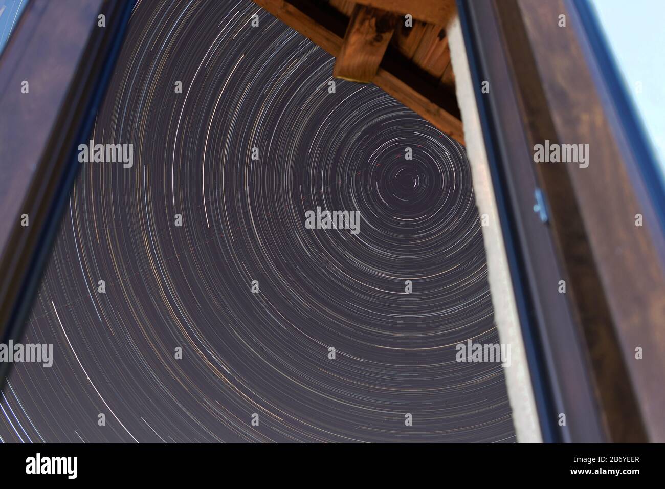 Sternenpfade in der Nähe des Nordstars, wie sie durch das Fenster eines Hauses gesehen werden Stockfoto